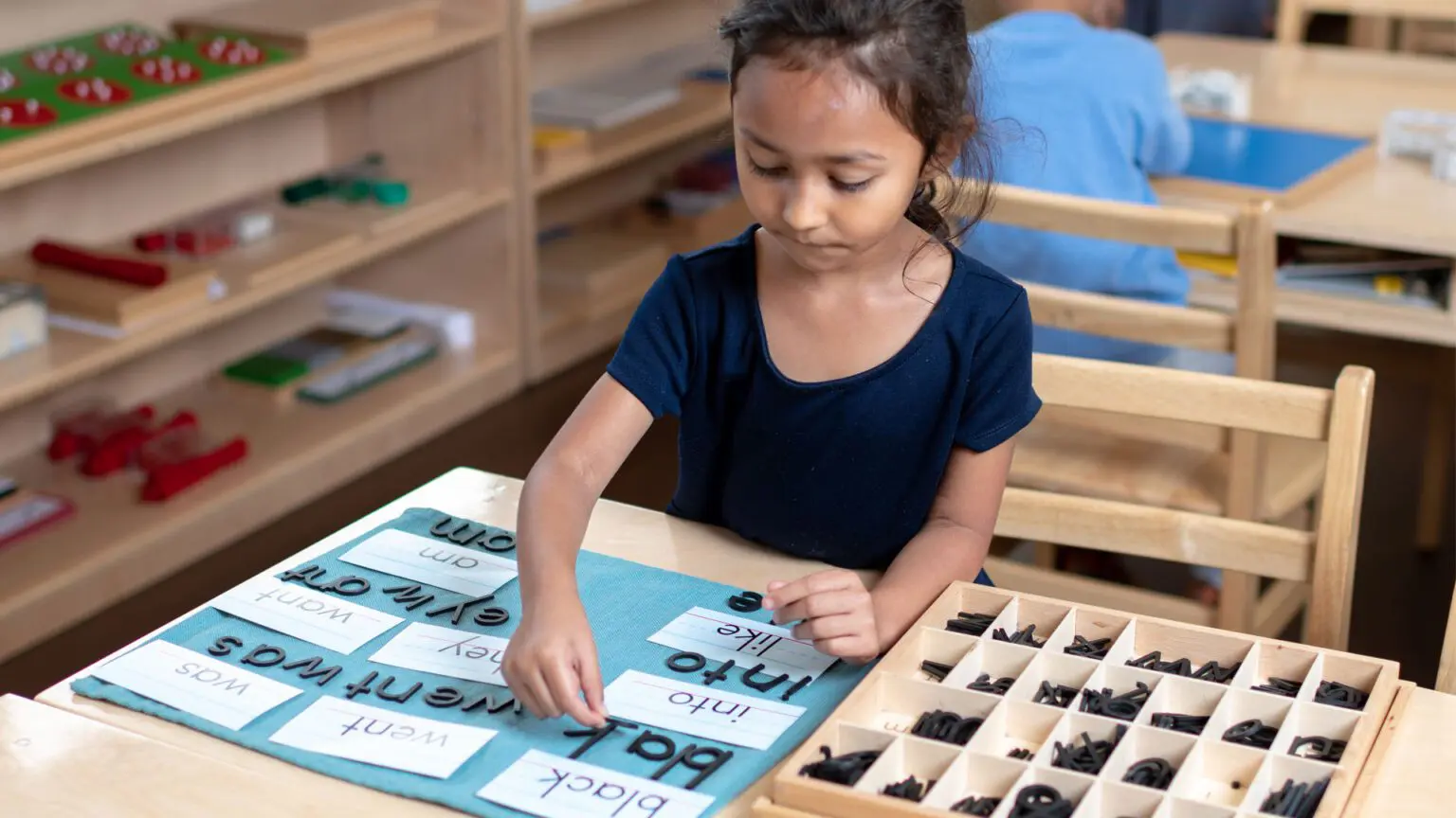 A girl is working on an activity at the table.