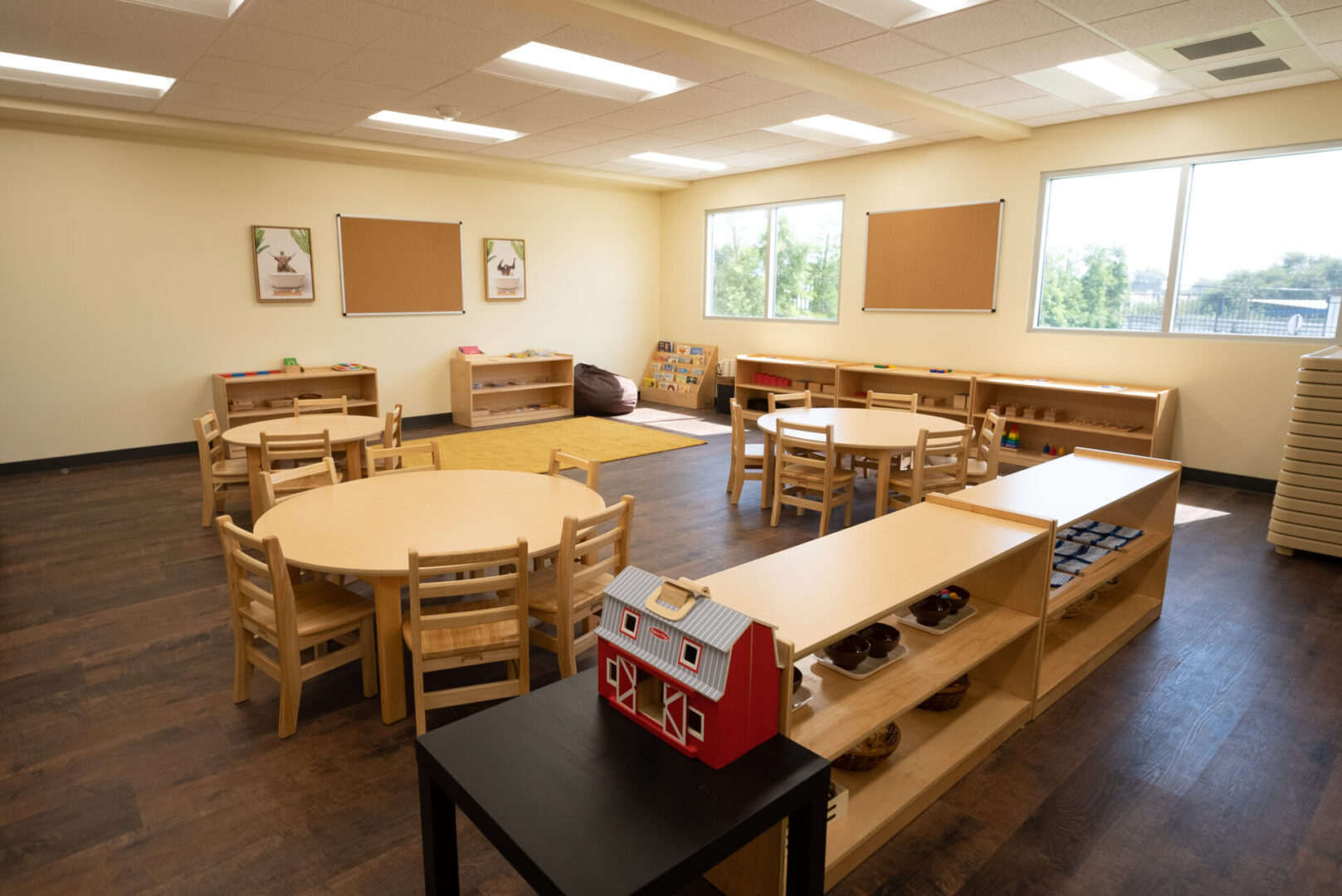 A classroom with tables and chairs, and a toy train.